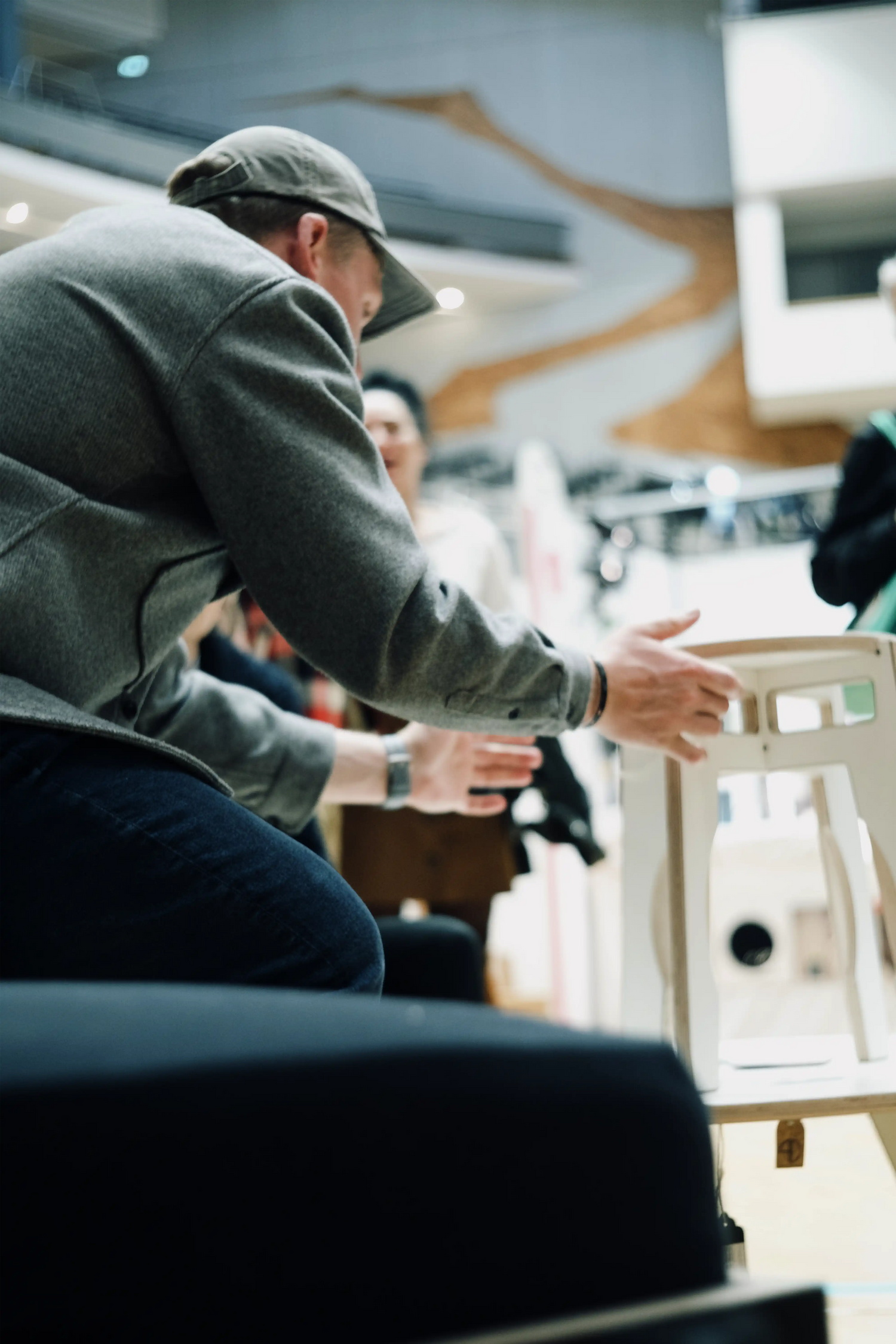 Möbeldesigner stellt Kunden einen Hocker aus Holz vor