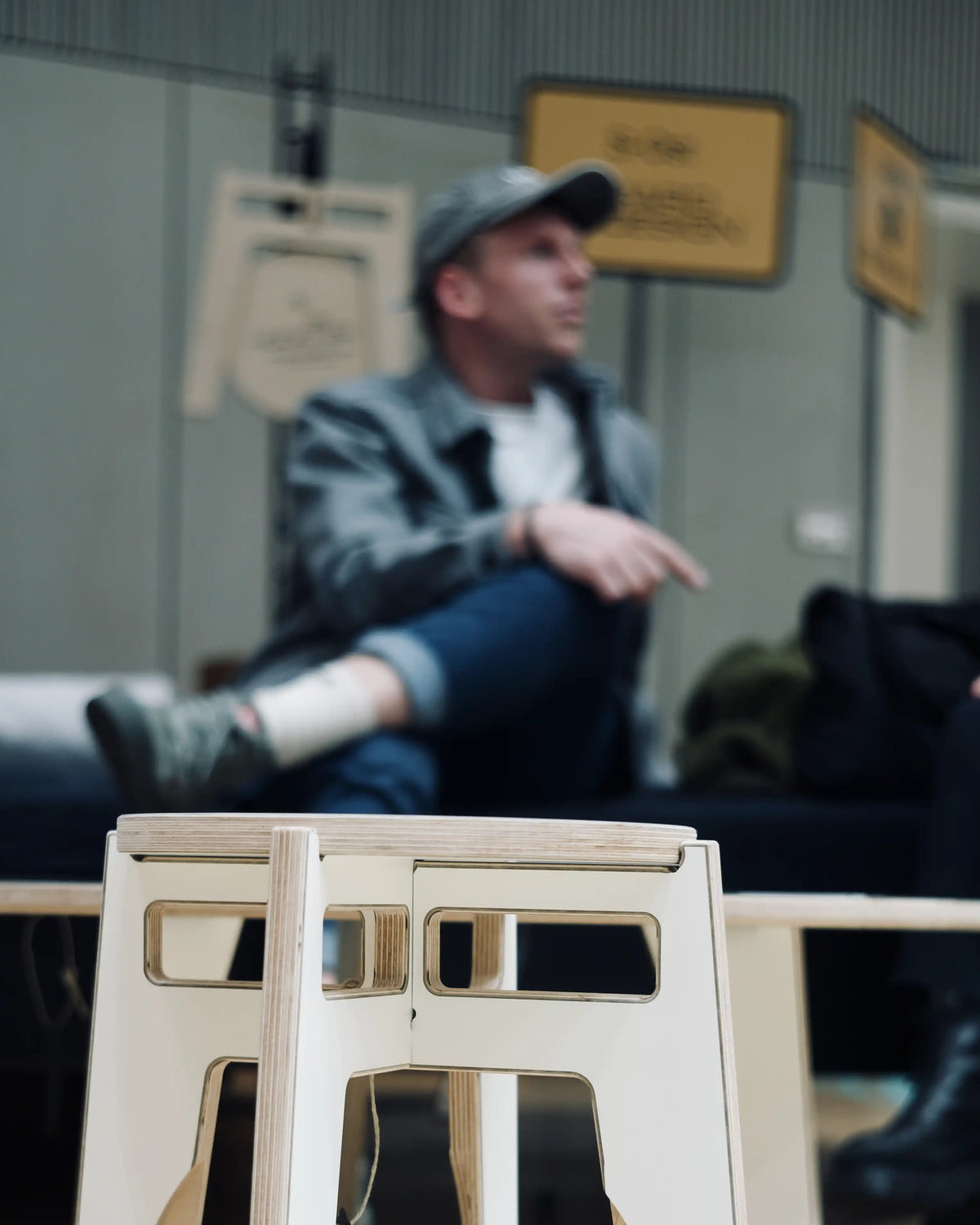 Designerhocker und Designer auf Möbelmesse